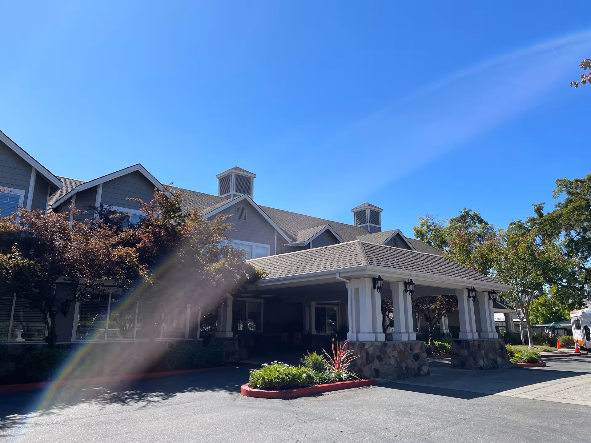 Sunrise of Danville facility exterior with a covered entrance and landscaping under a clear blue sky.