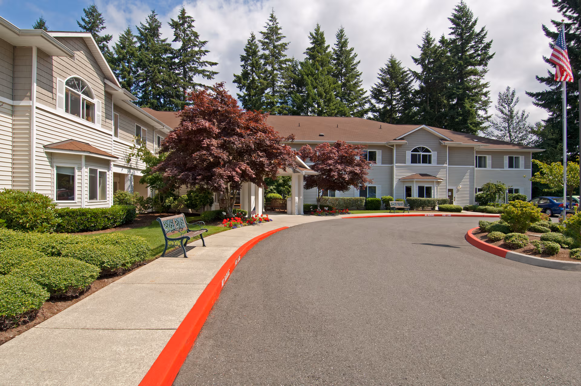 Two-story Patriots Glen senior living building with a curved driveway and landscaping.