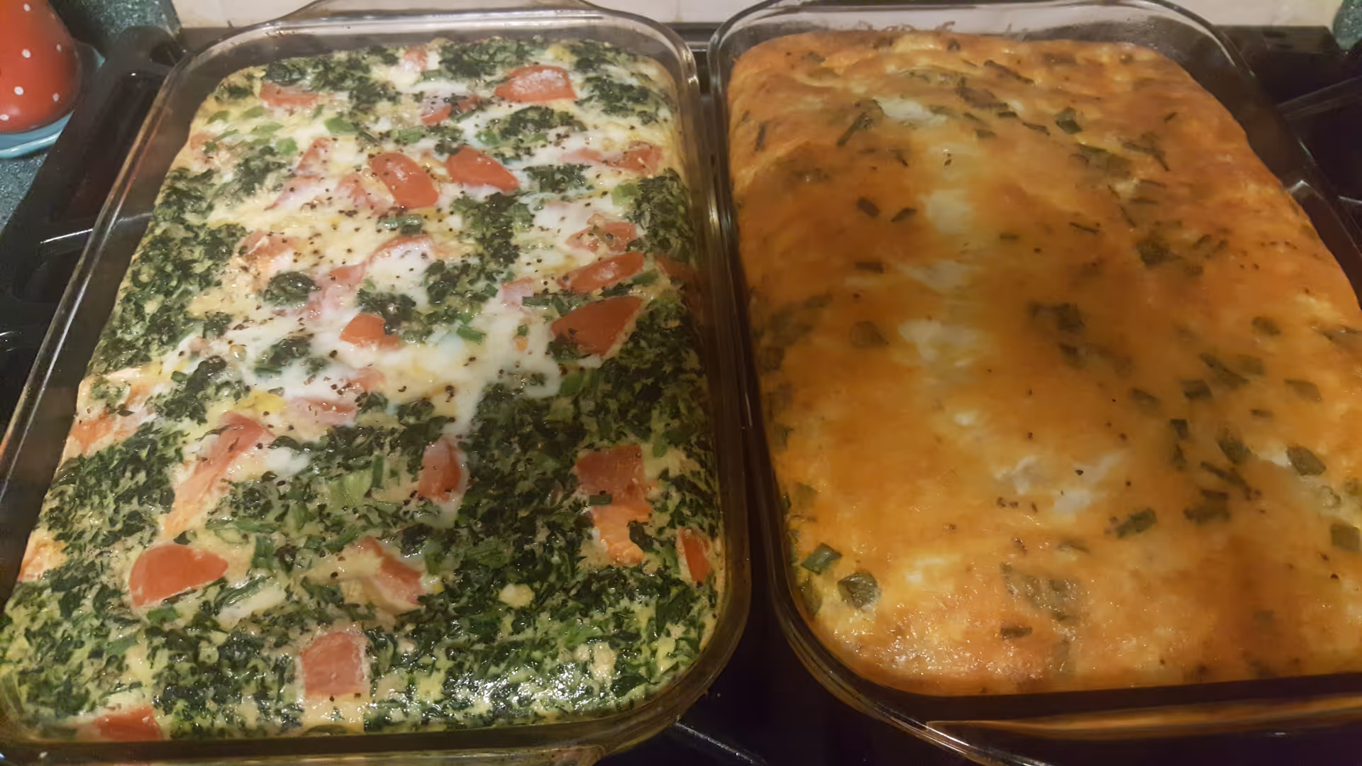 Two large casserole dishes sit on a kitchen counter, filled with greens and cheese.