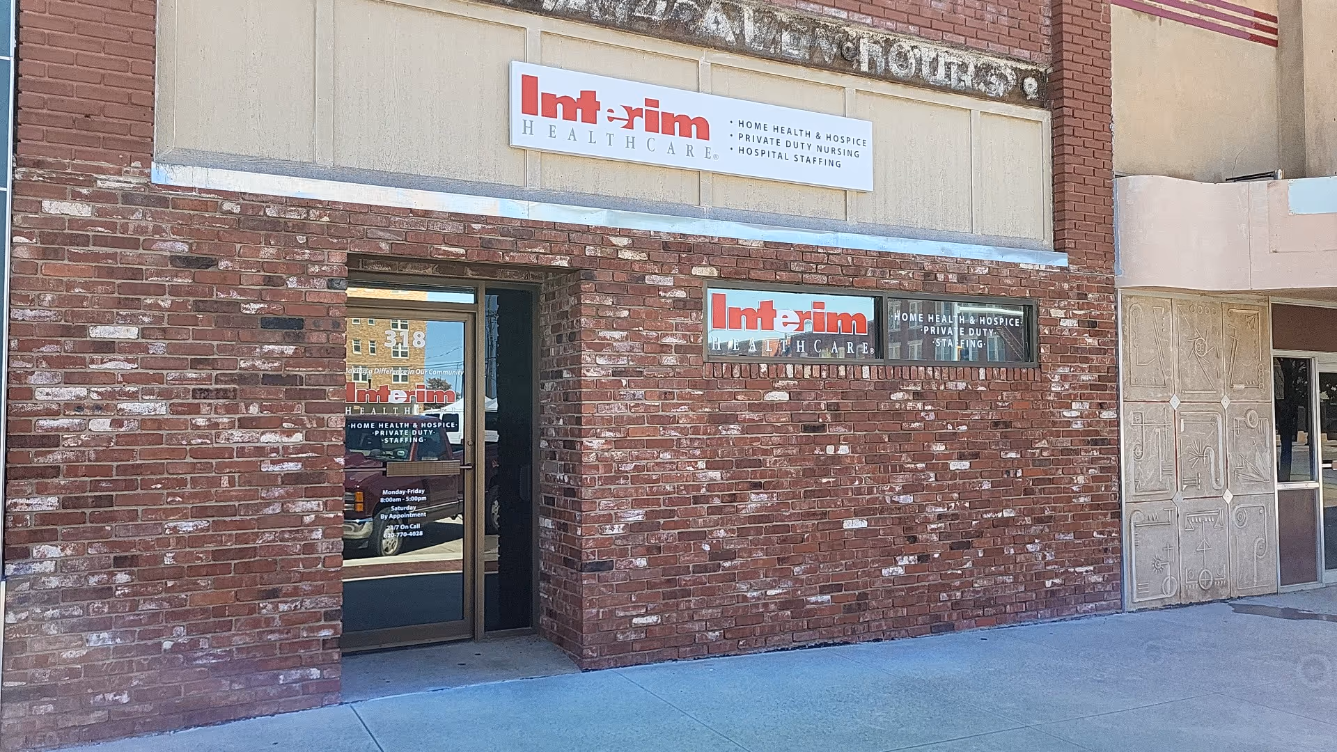 Brick exterior of Interim HealthCare facility with glass entrance doors and signs above the doorway.