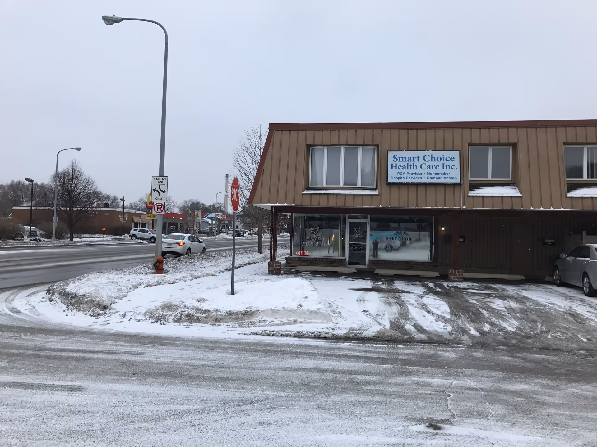 Exterior view of a brown storefront with Smart Choice Health Care sign in snowy parking lot