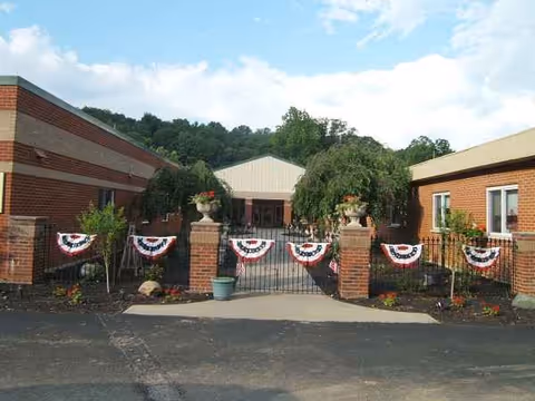 Exterior view of River Valley Nursing Home with brick entrance, gate, and patriotic bunting.