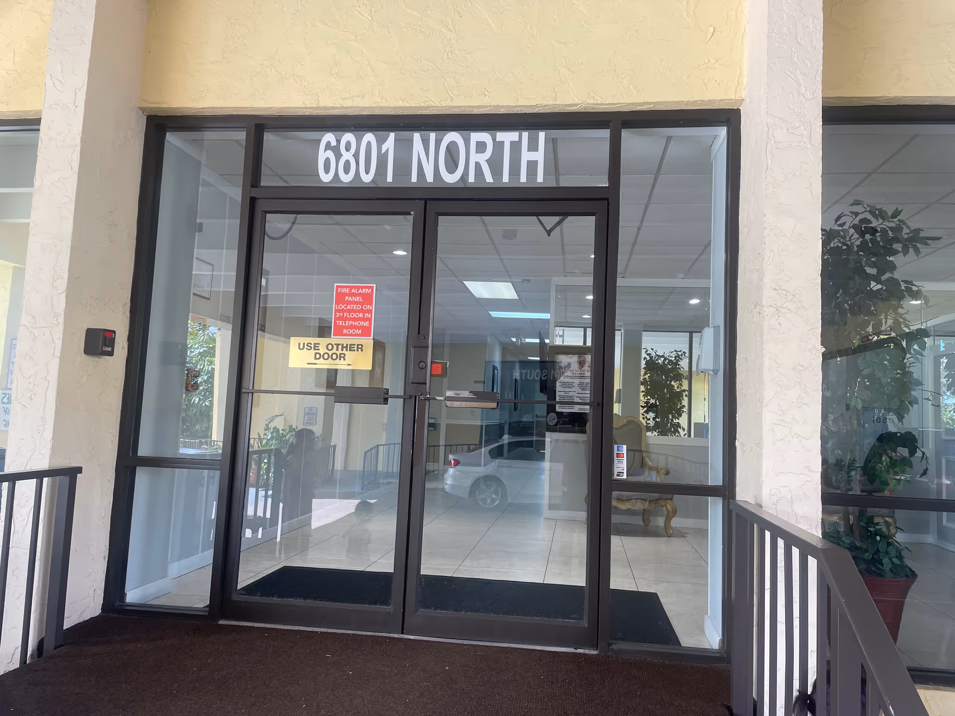 Bright lobby visible through glass double doors labeled 6801 North