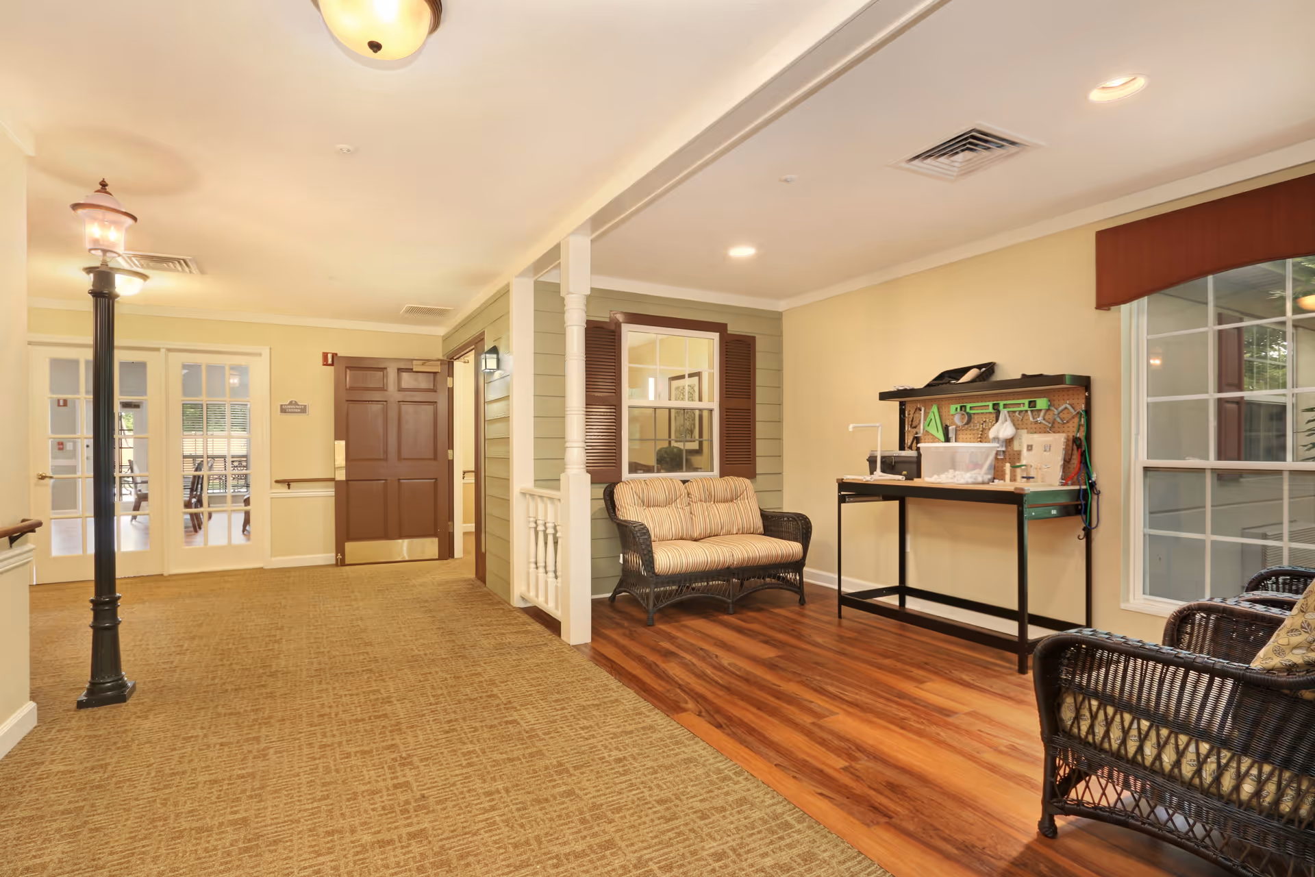 Interior lobby of a Brookdale senior living facility with seating, a workbench, and double doors.