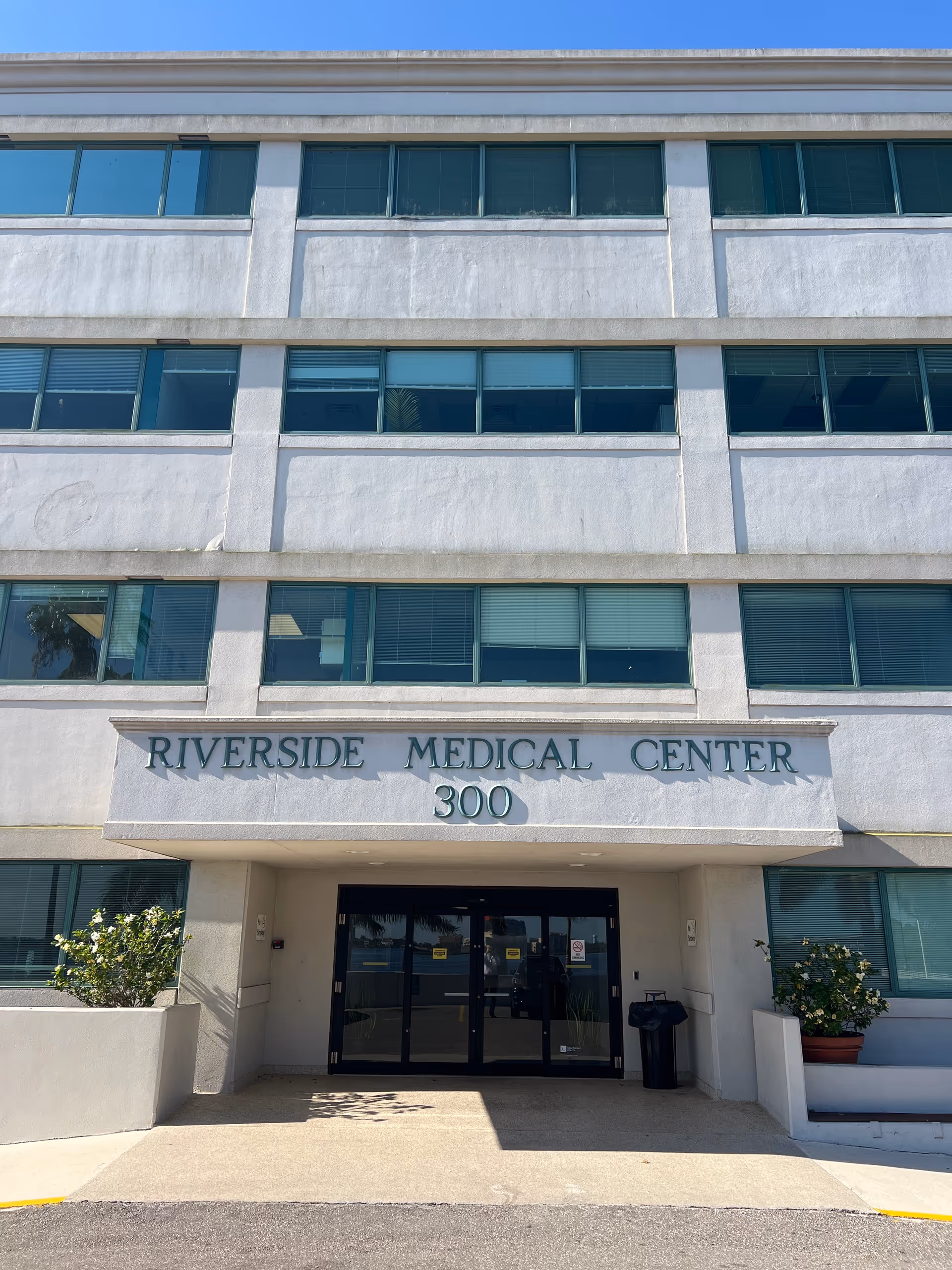 Front facade of a multi-story medical center with glass windows and a central entrance.