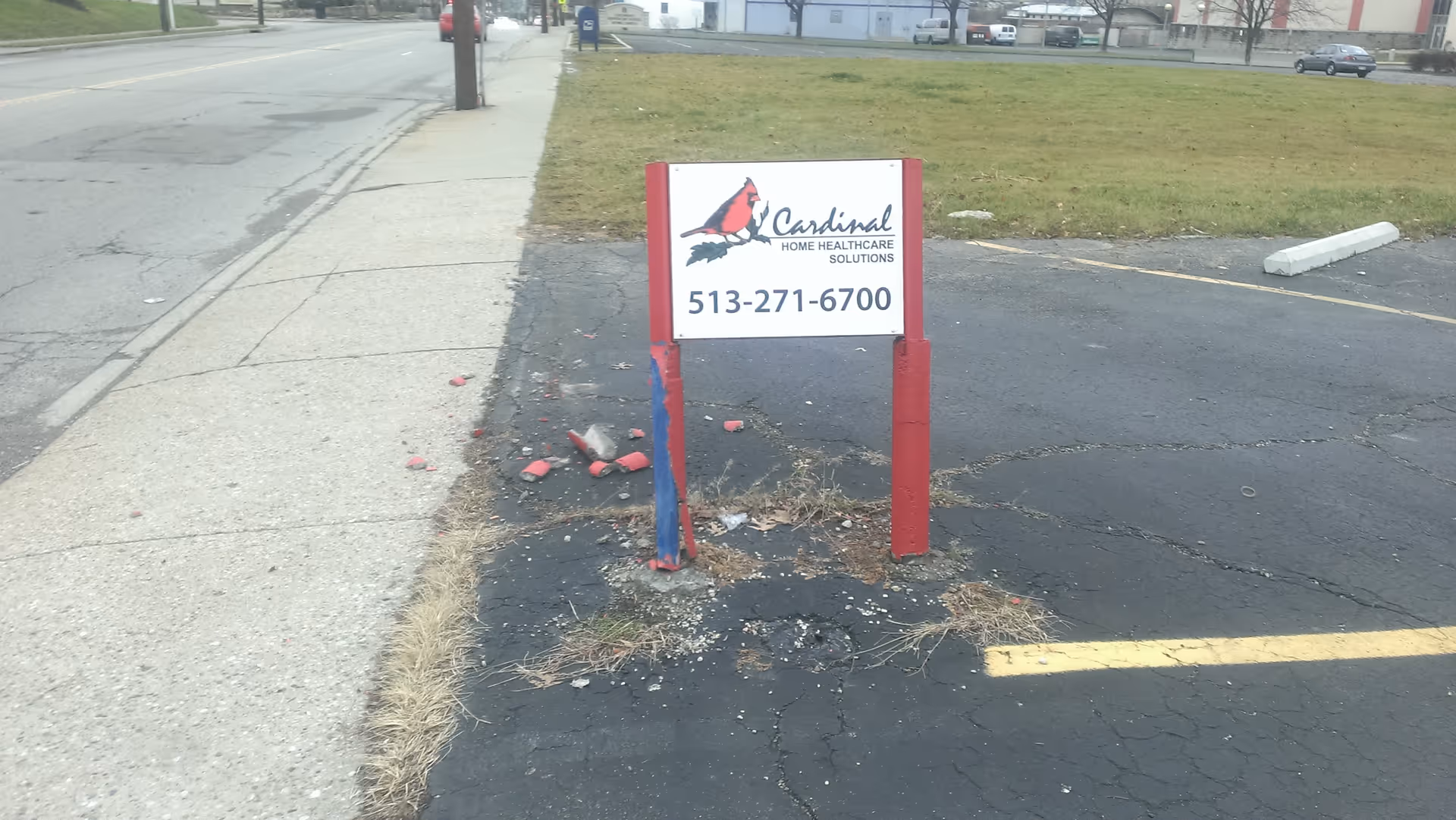 Cardinal Home Healthcare Solutions sign on posts in a cracked parking lot