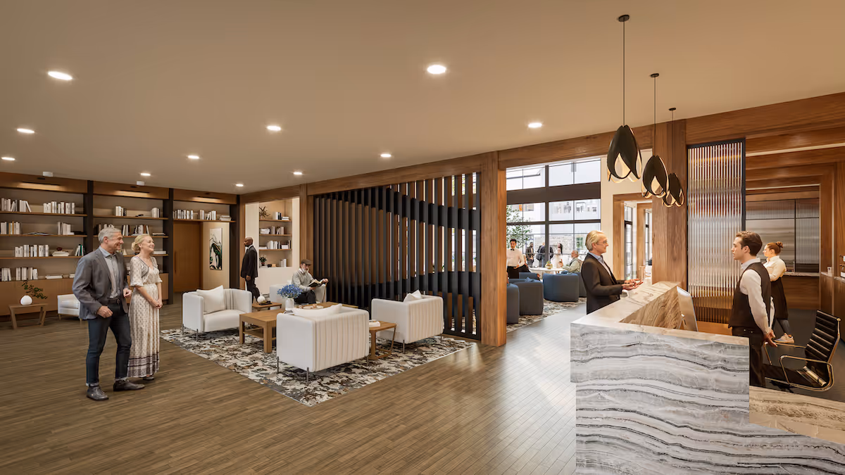 Spacious wood-accented reception and lounge area with seating, bookshelves, and staff at a marble front desk.