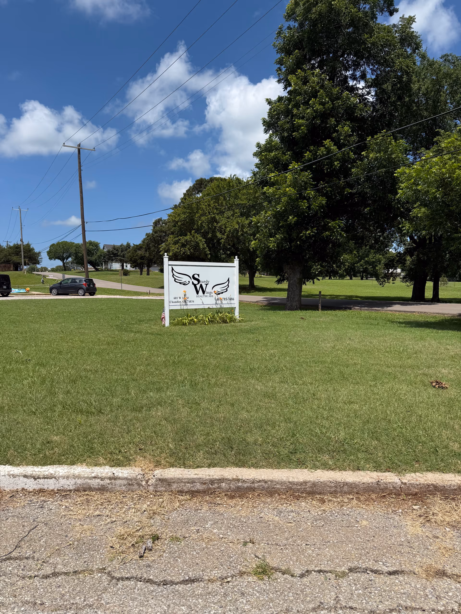 Sunny day view of Chandler Therapy & Living Center sign on a grassy lawn.