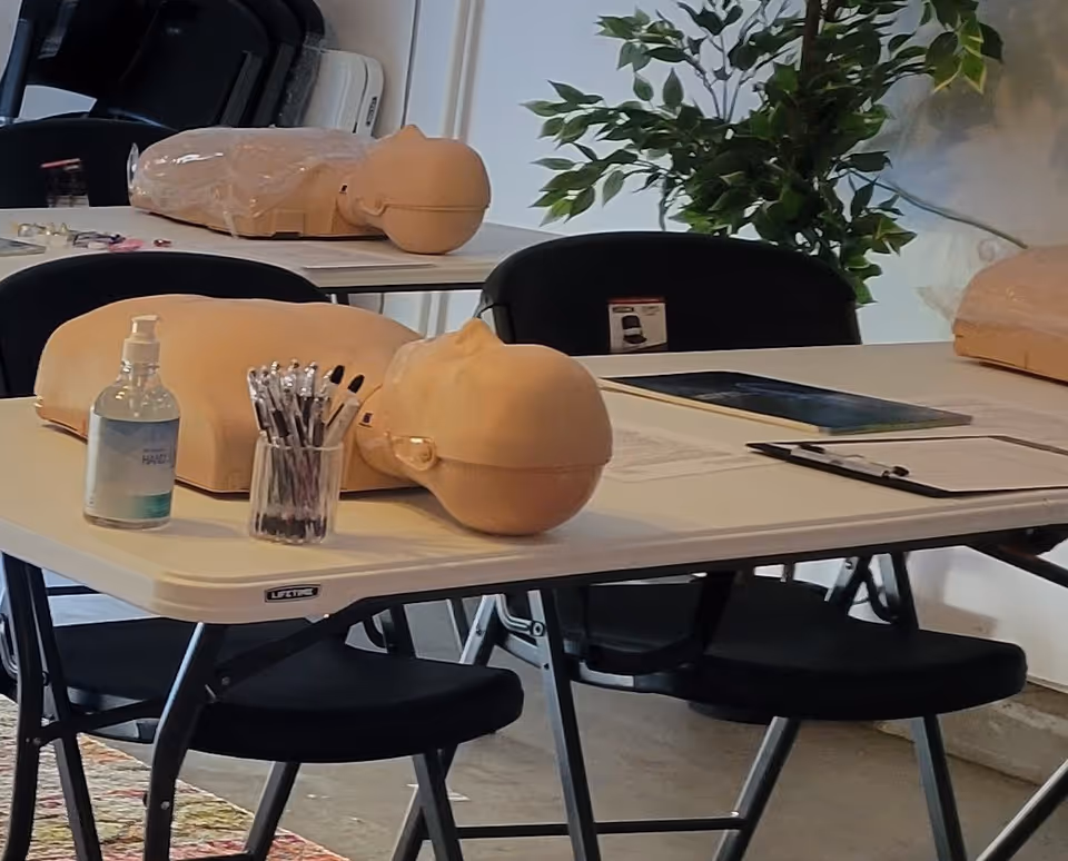 Interior CPR training room with lifelike mannequins on tables and supplies.