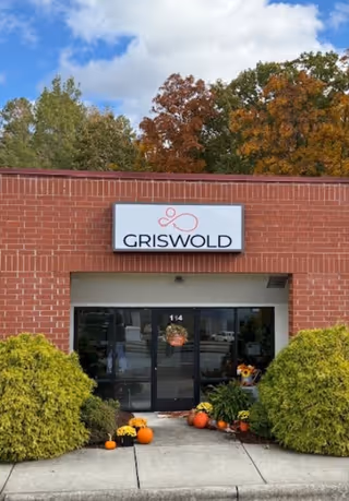 Brick facility entrance with Griswold sign and autumn pumpkins decorating the doorway.