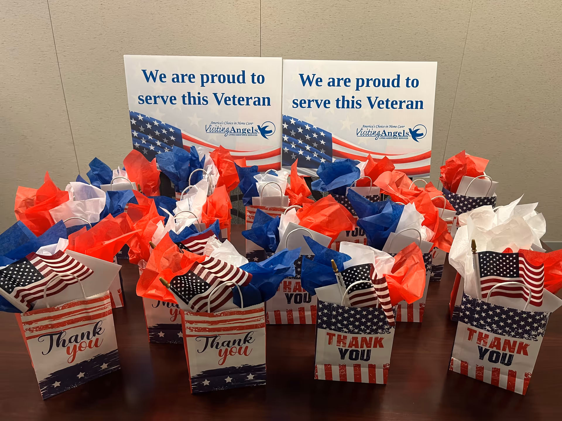 Patriotic gift bags on a table beside veteran celebration signs.
