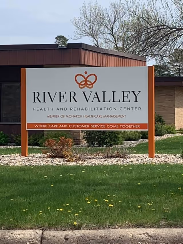 River Valley Health and Rehabilitation Center sign on a green lawn in front of a building.
