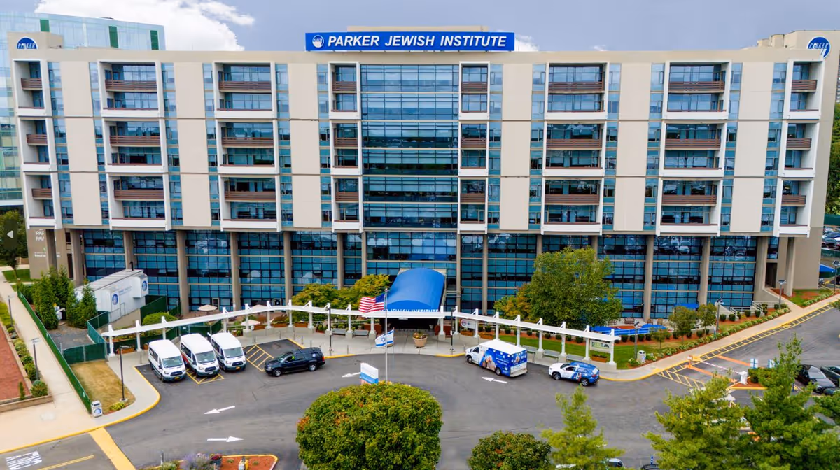 A multi-story Parker Jewish Institute exterior with a parking lot and entrance canopy.