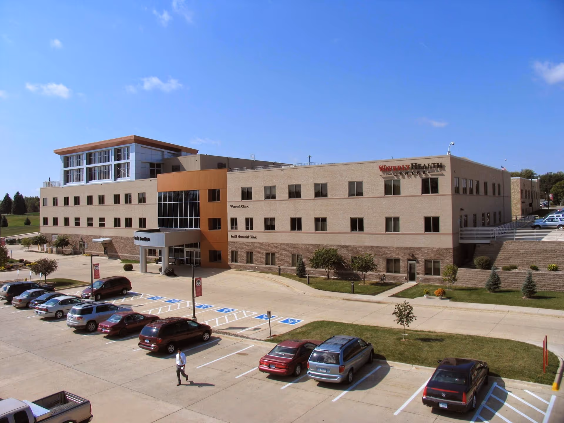 Exterior view of Waverly Health Center, a large multi-story facility with a parking lot.