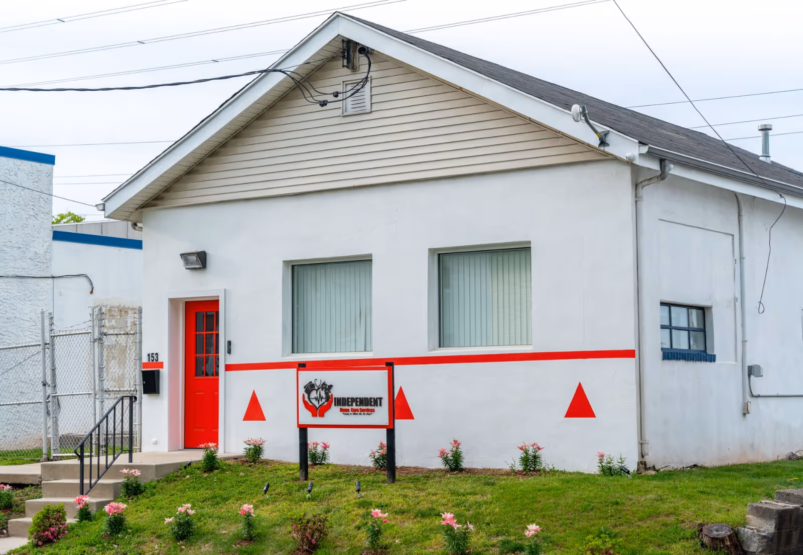 Small white building with red door and stripe, front sign reading Independent.