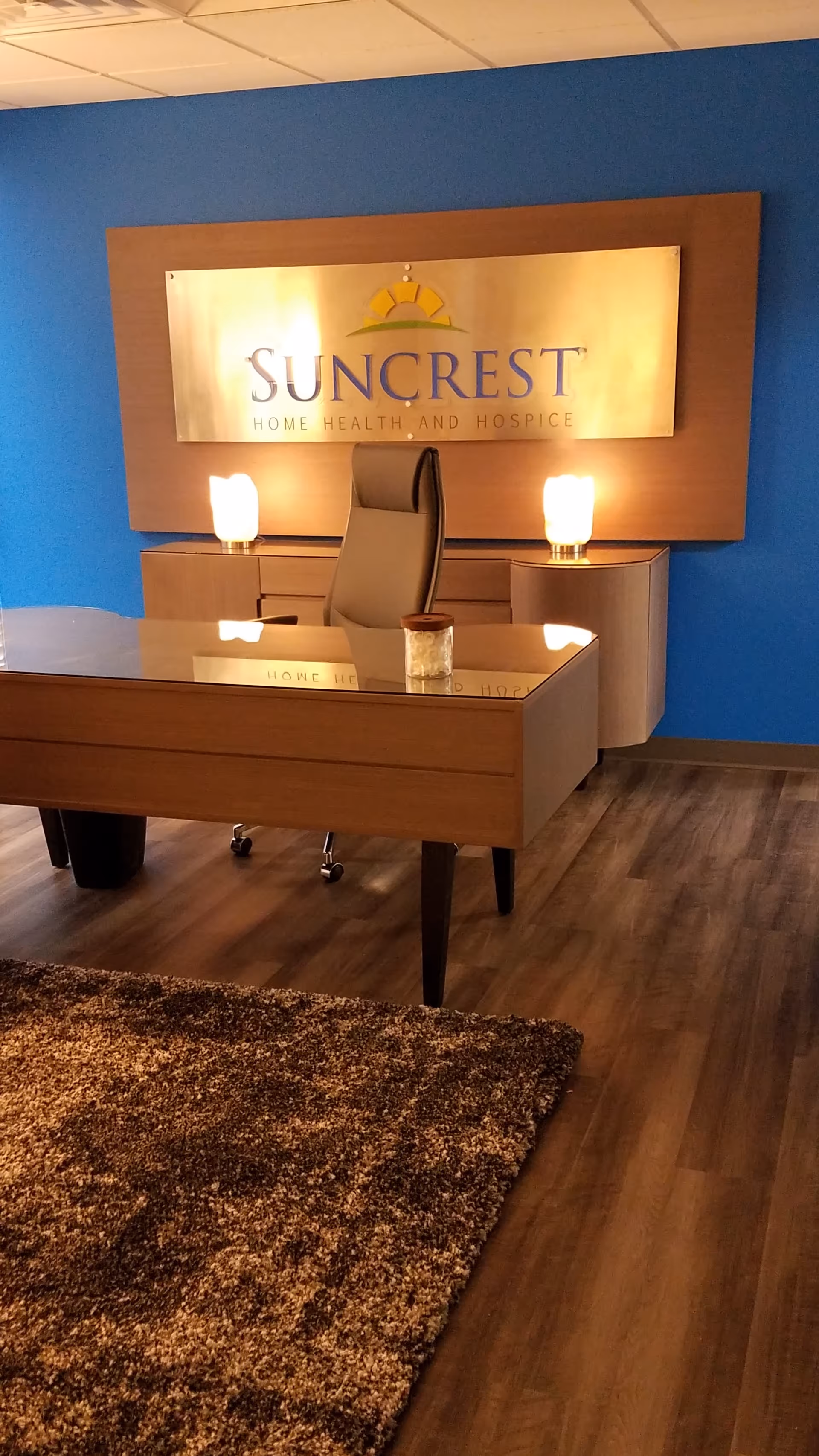 Reception desk with Suncrest sign and blue accent wall in a modern lobby.
