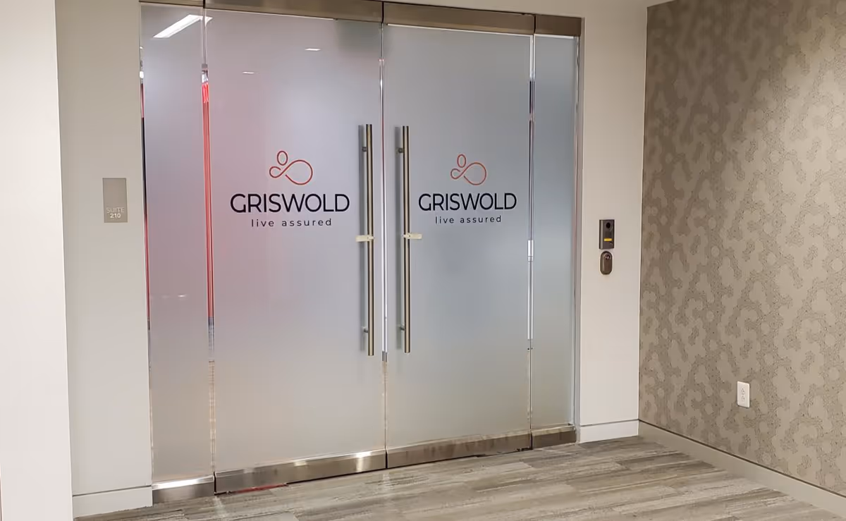 Double glass doors with Griswold logo in a modern interior corridor.