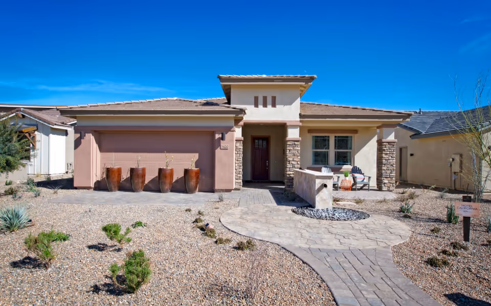 Trilogy at Wickenburg Ranch exterior: sunlit single-story entrance with curved path and desert landscaping.