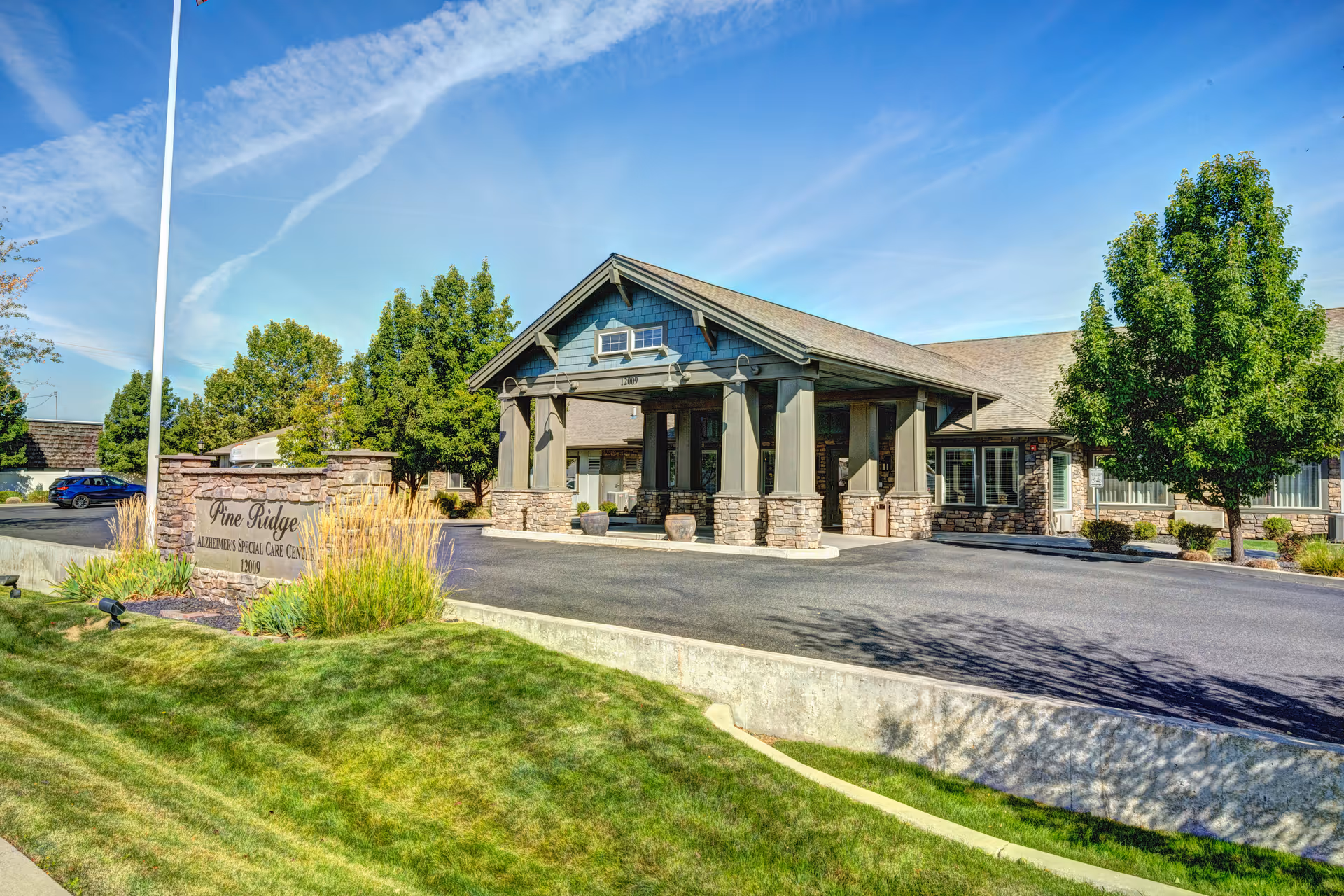 Front view of Pine Ridge Alzheimer's Special Care Center exterior with entrance and landscaping.