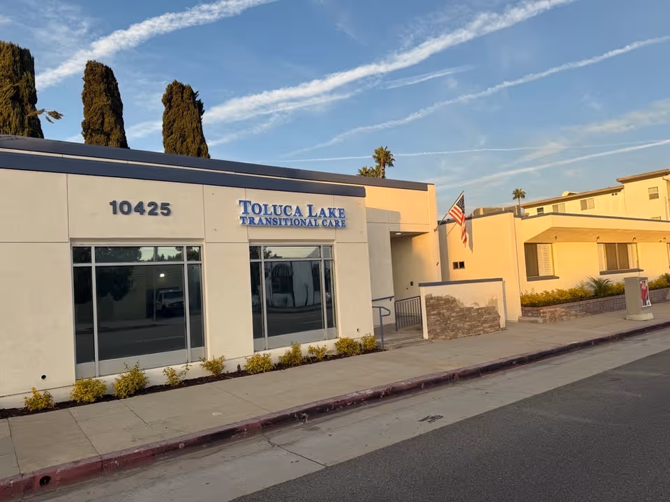 Exterior view of a single-story care facility with Toluca Lake Transitional Care sign.