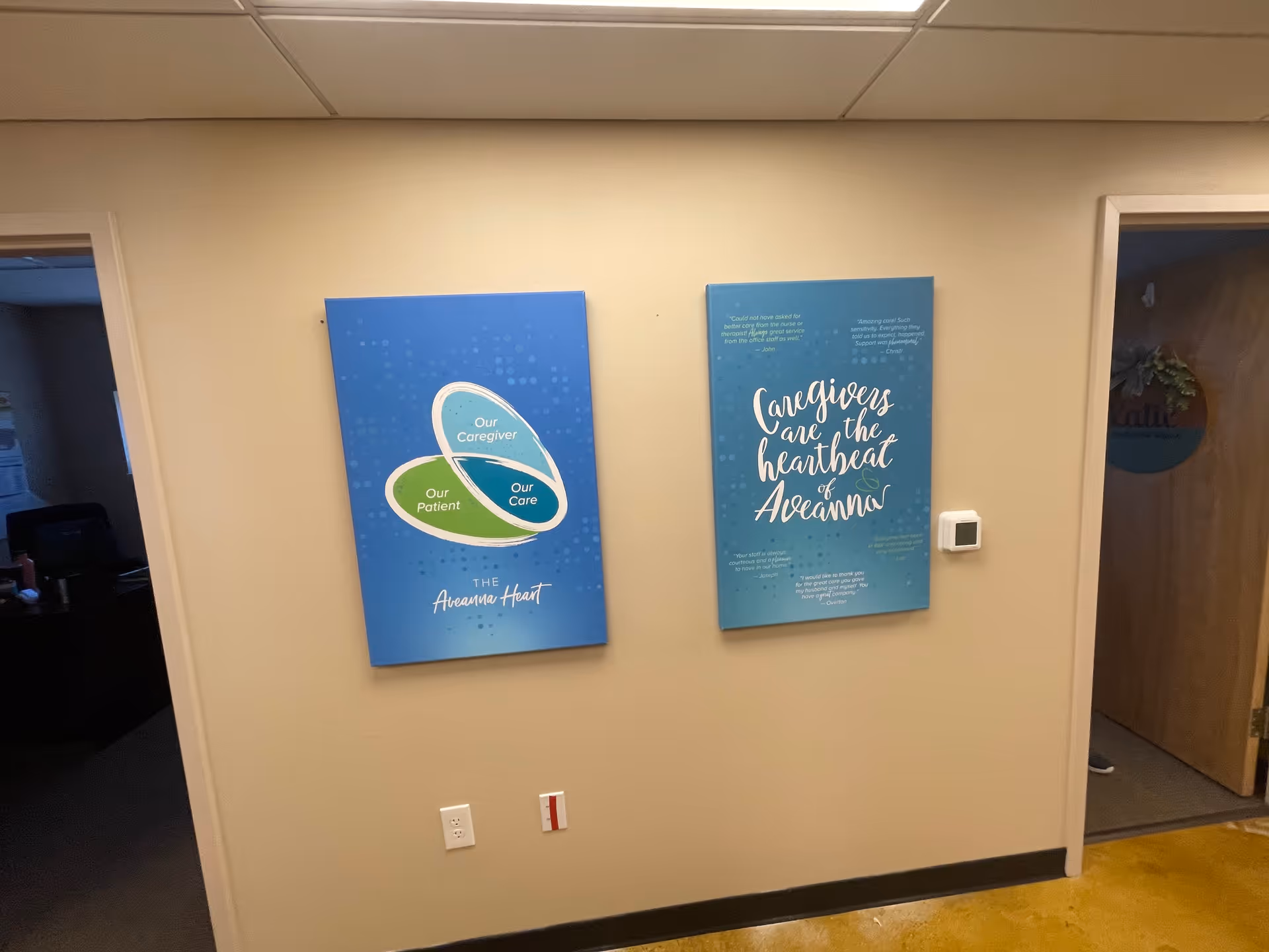 Beige hallway with two blue posters on the wall and doorway openings.