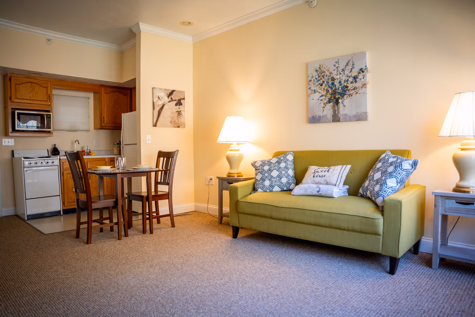 Bright living area with a lime green sofa, dining table, and kitchenette in Woodland Terrace.