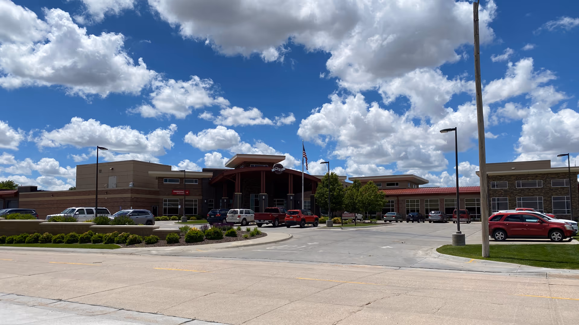 Exterior view of Phelps Memorial Health Center with parking lot, blue sky, and landscaped entrance