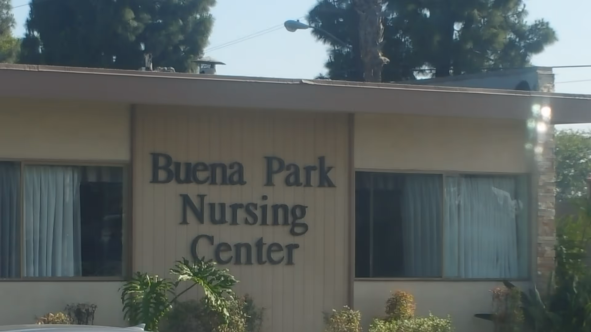 Front exterior of Buena Park Nursing Center with large sign and windows.