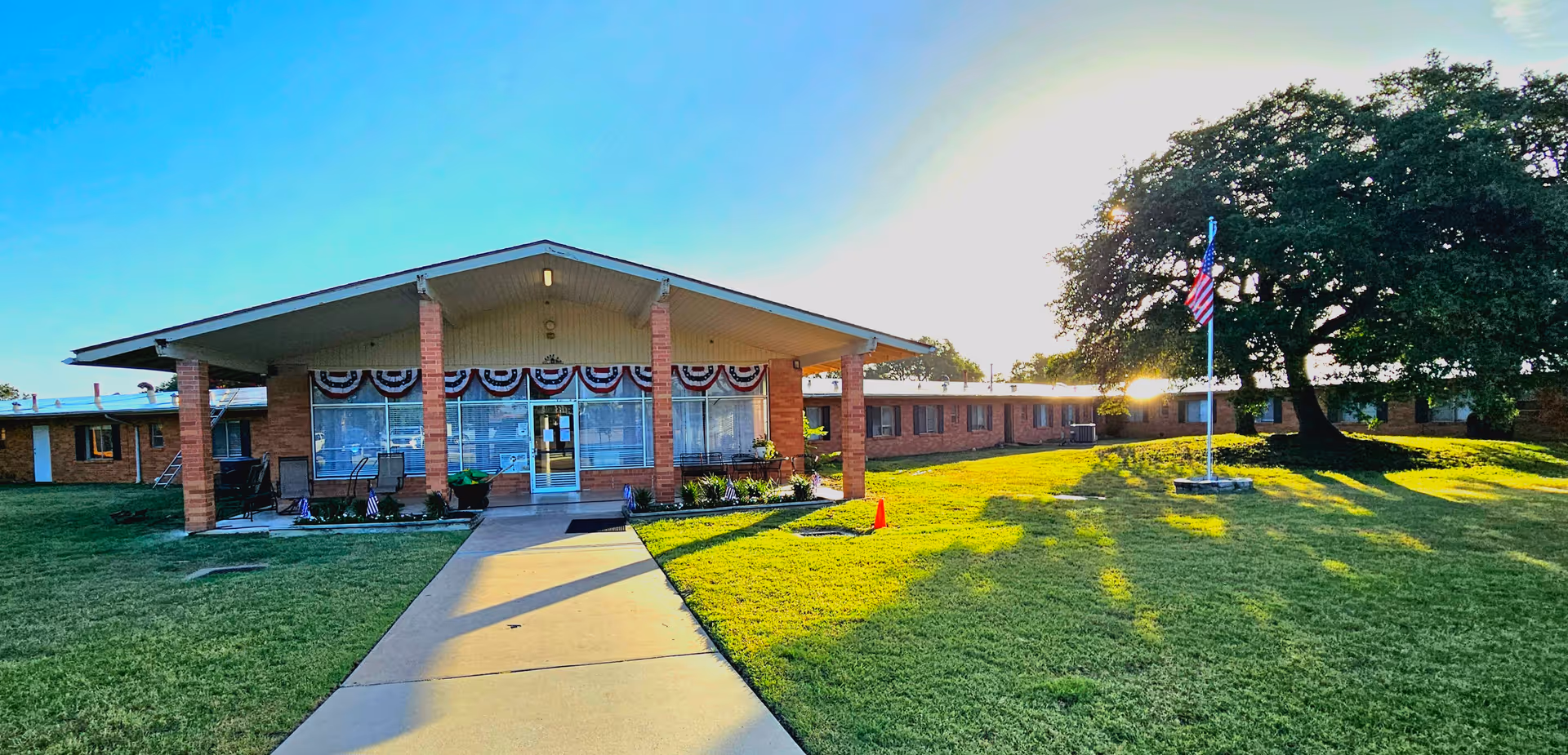 Front exterior of Monte Siesta Nursing & Rehabilitation with walkway, lawn, and flag.
