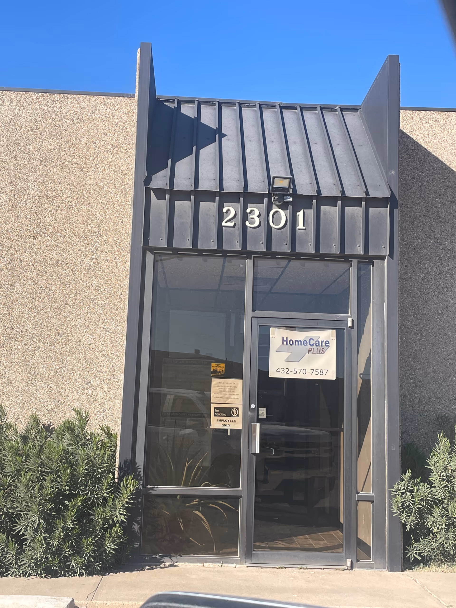 Front entrance of HomeCare Plus with address 2301 and glass door.