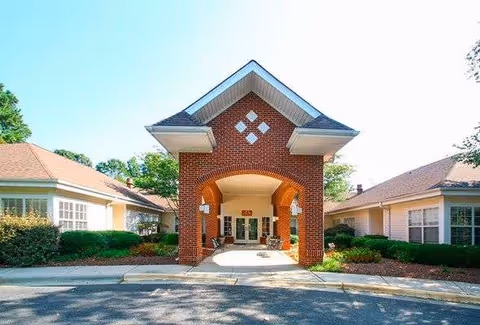 Brick archway entrance to a senior living building with landscaped sides.