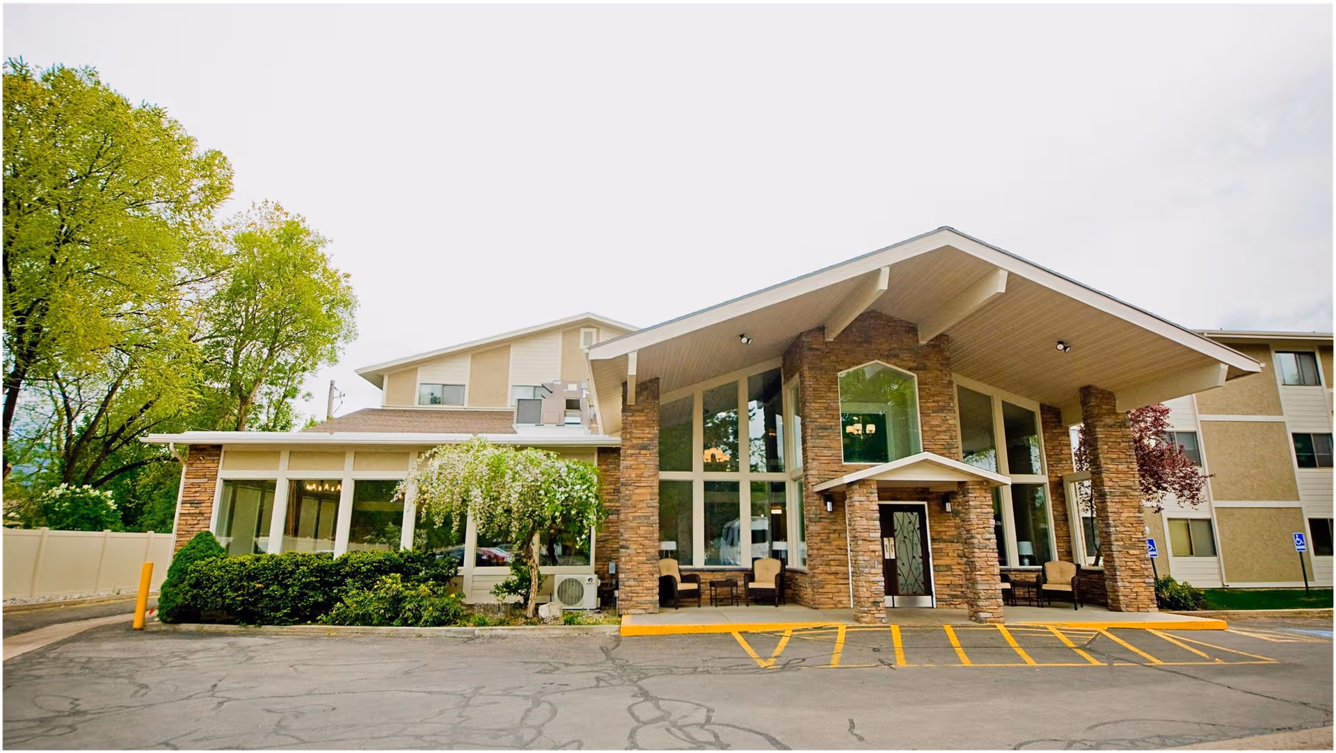 Exterior view of Williamsburg Retirement Community building with stone pillars and a covered entrance.