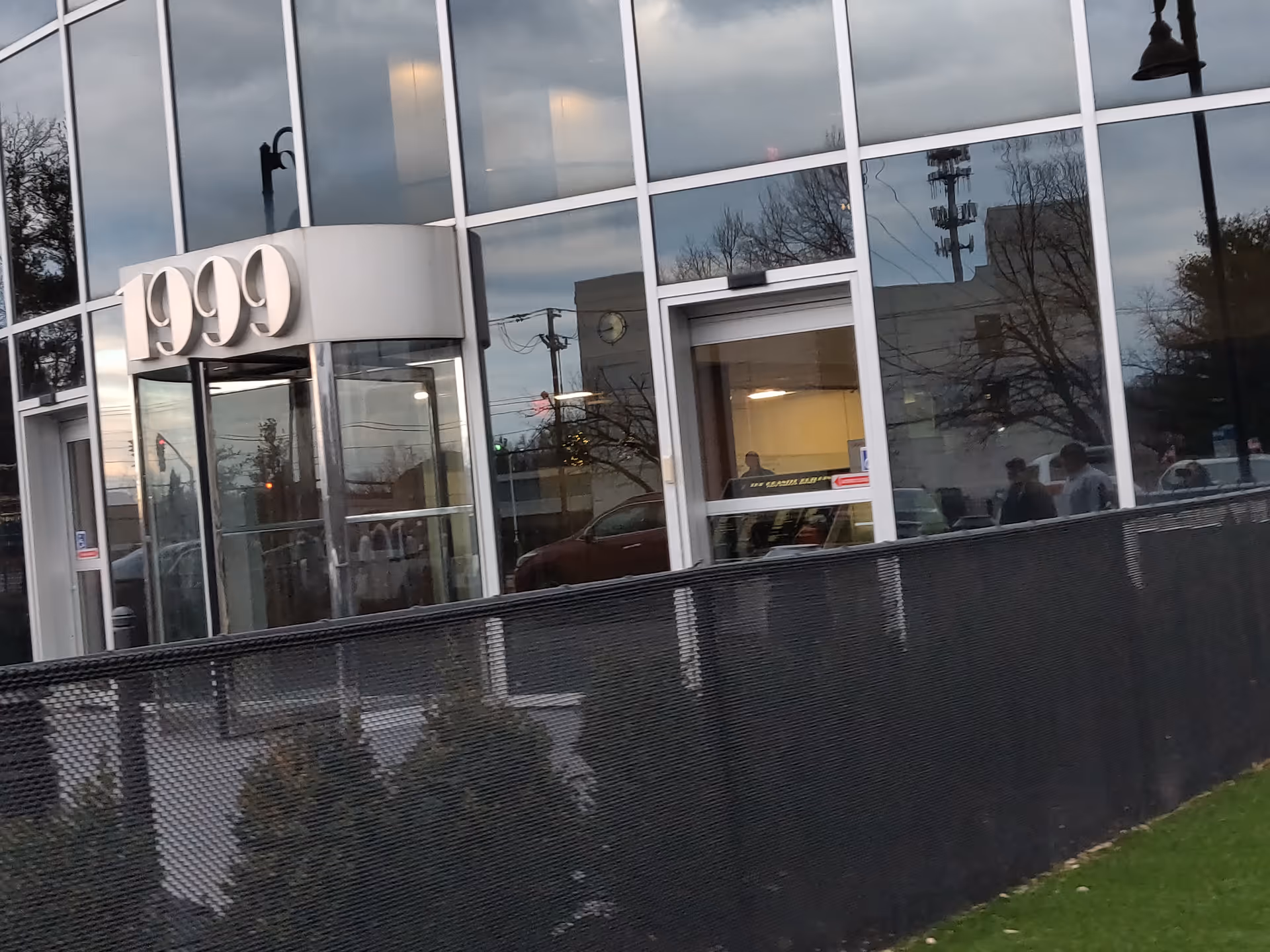 Front view of a glass-faced medical building with 1999 sign and fence.