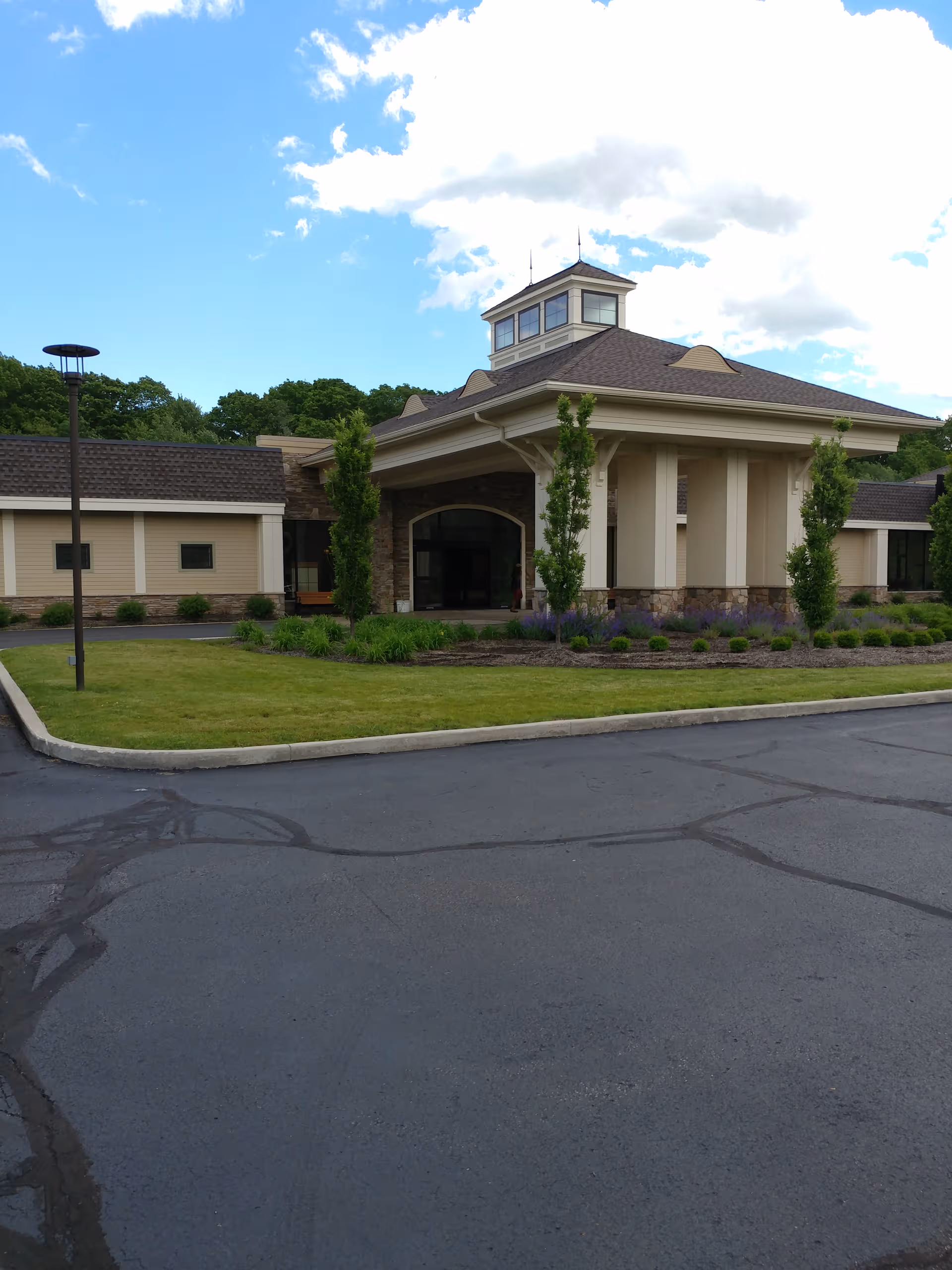 Front view of The Atrium of Aurora with entrance, pillars, and landscaped grounds.