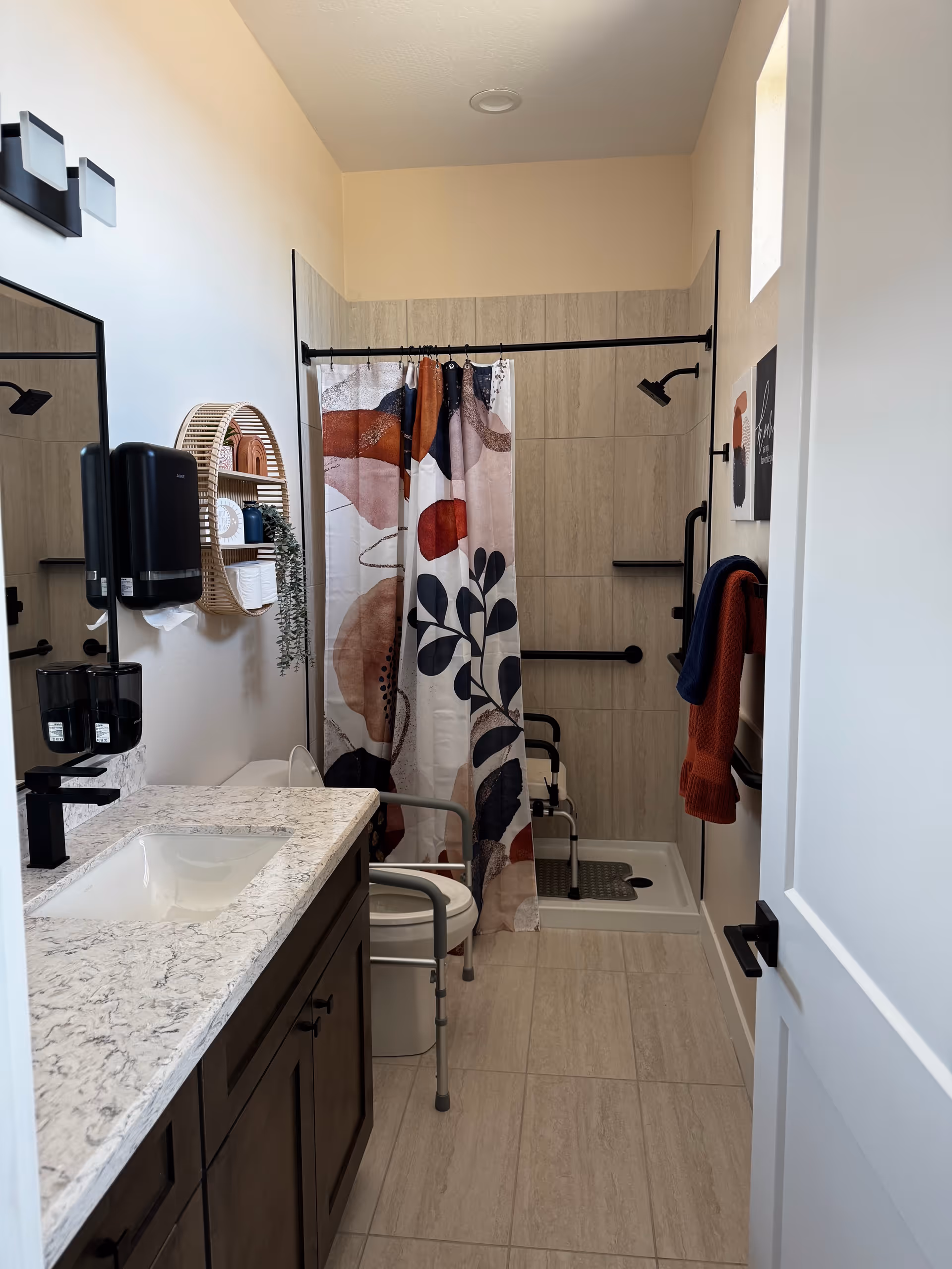 Accessible bathroom in a senior living facility with a shower, grab bars, and sink.