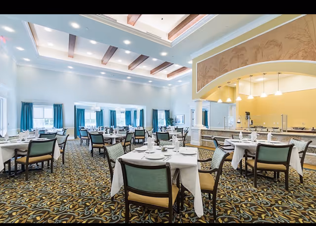 Elm Tree Lodge dining hall with round tables, white linens, and a buffet area.