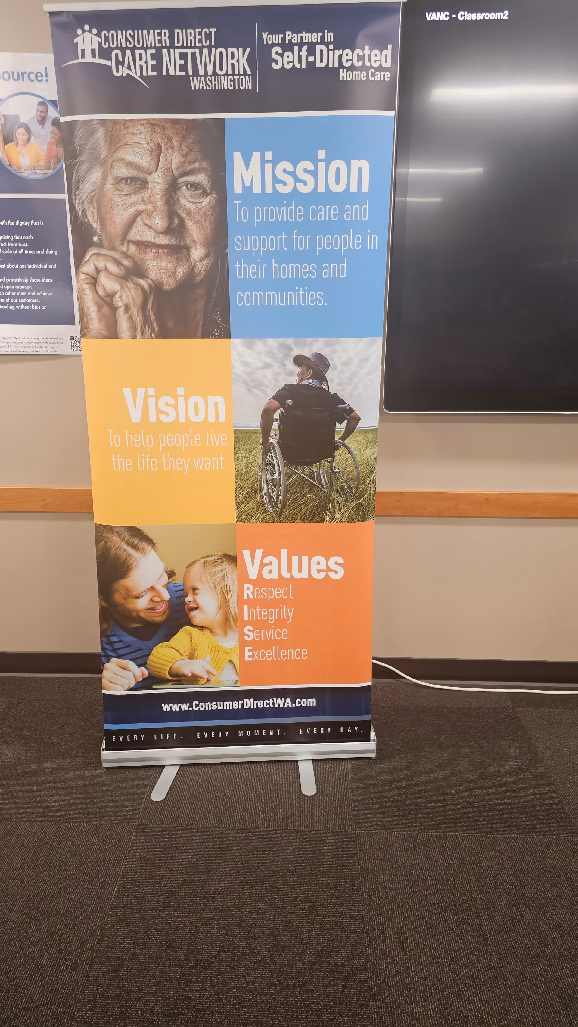 Vertical banner display promoting CDWA mission, vision, and values in a hallway.