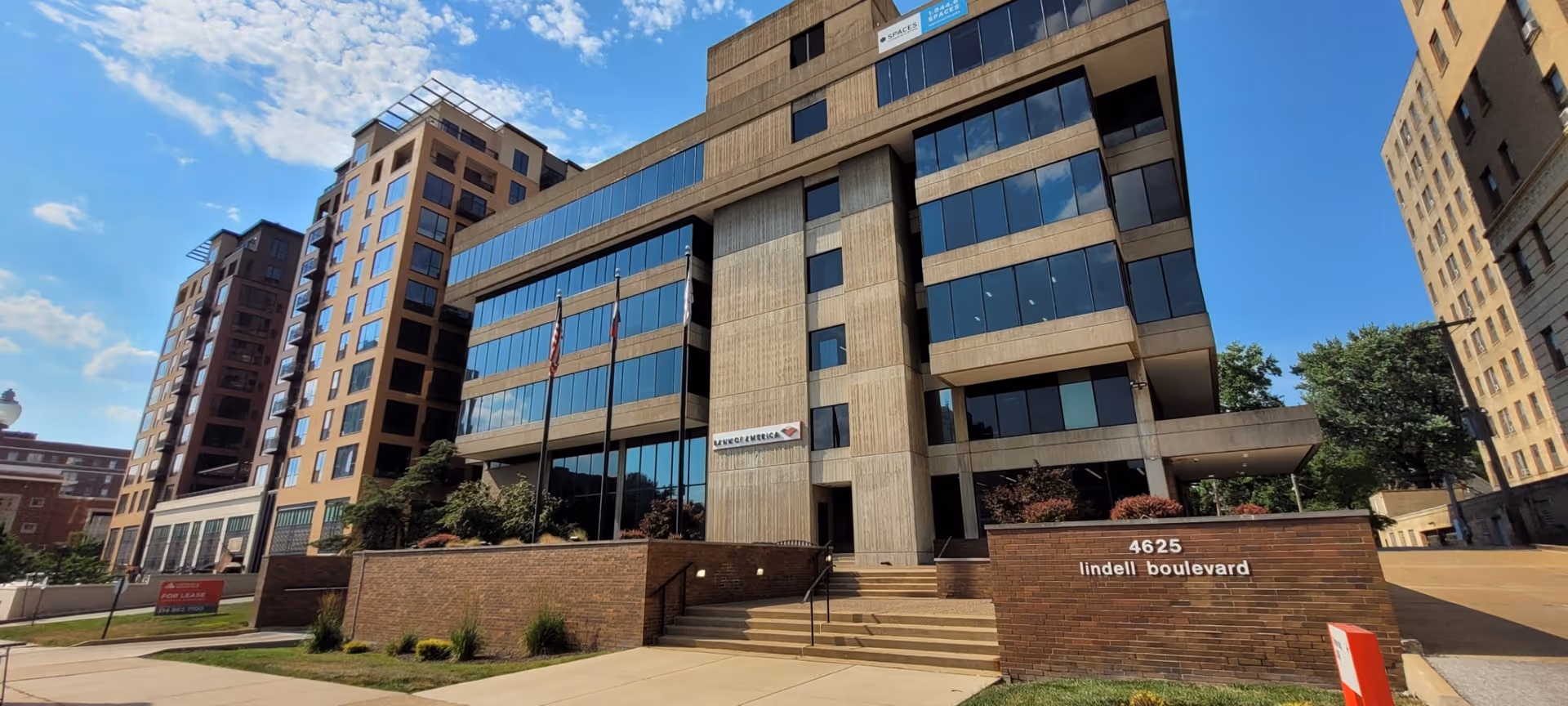 Exterior view of a modern multi-story building with glass windows and brick facade.