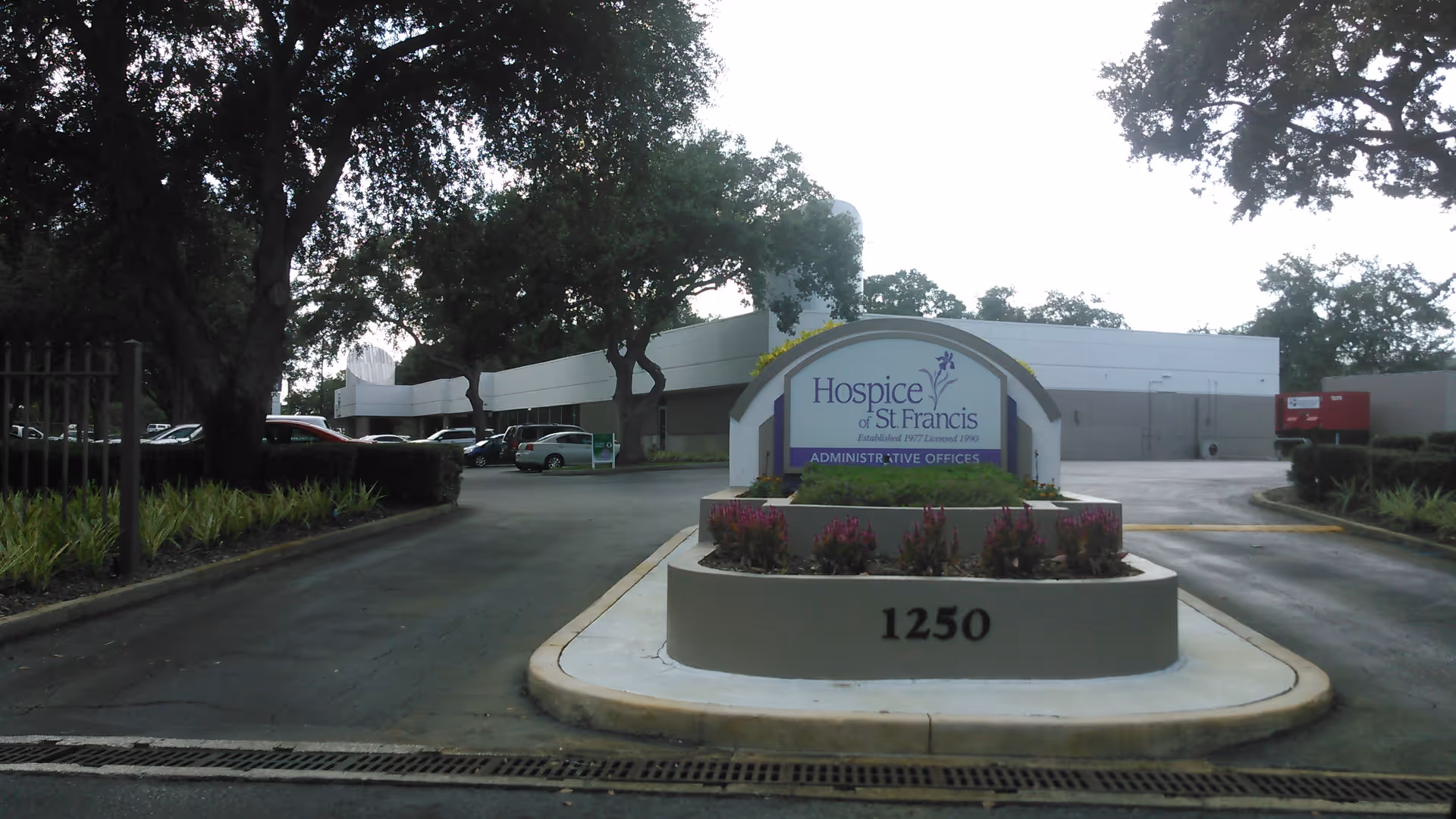 Exterior view of Hospice of St. Francis entrance with a circular sign and address 1250