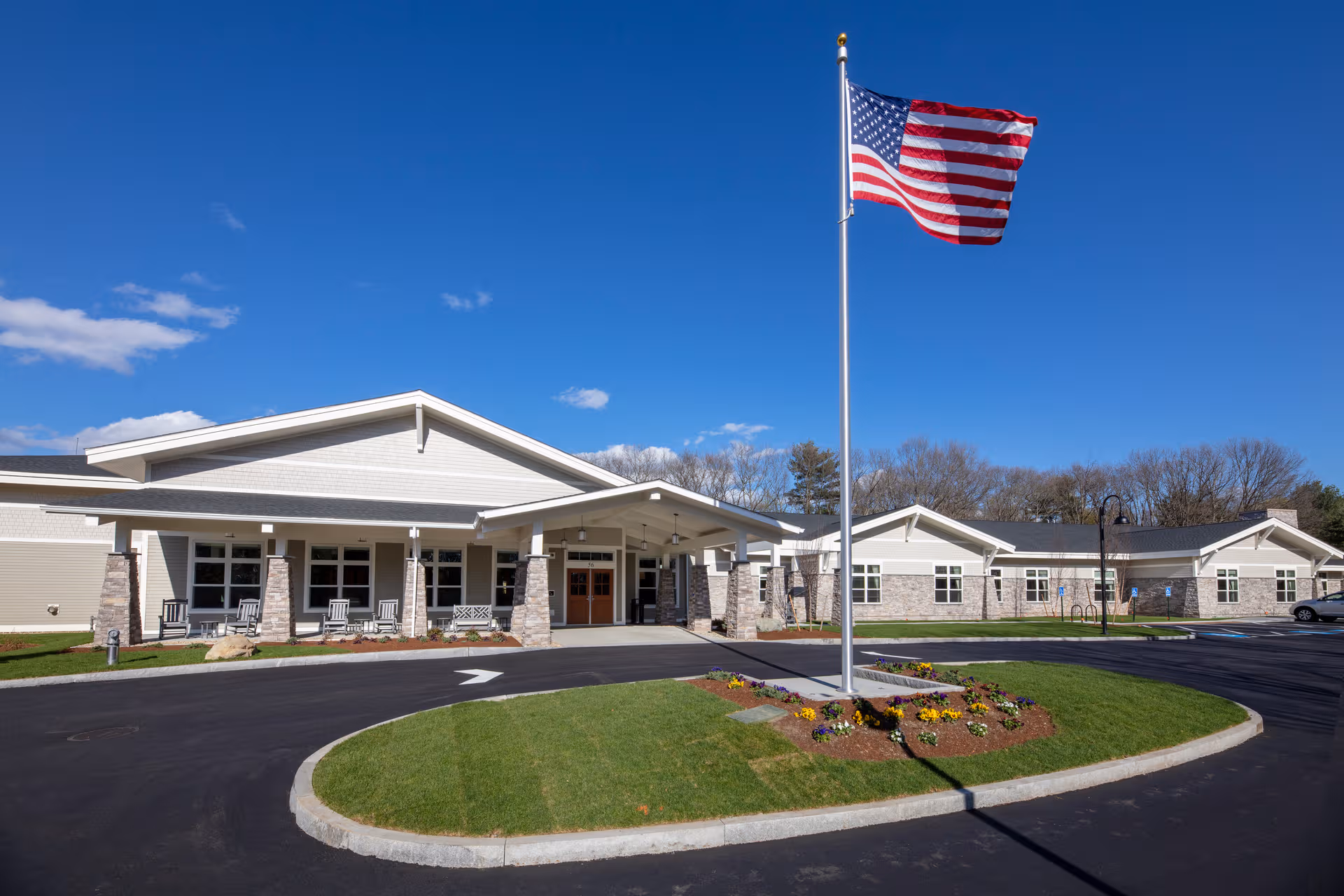 Front exterior of Bridges by EPOCH at Lexington with flagpole and landscaped entrance.