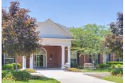Front view of Astoria Care Home entrance with brick facade and trees.