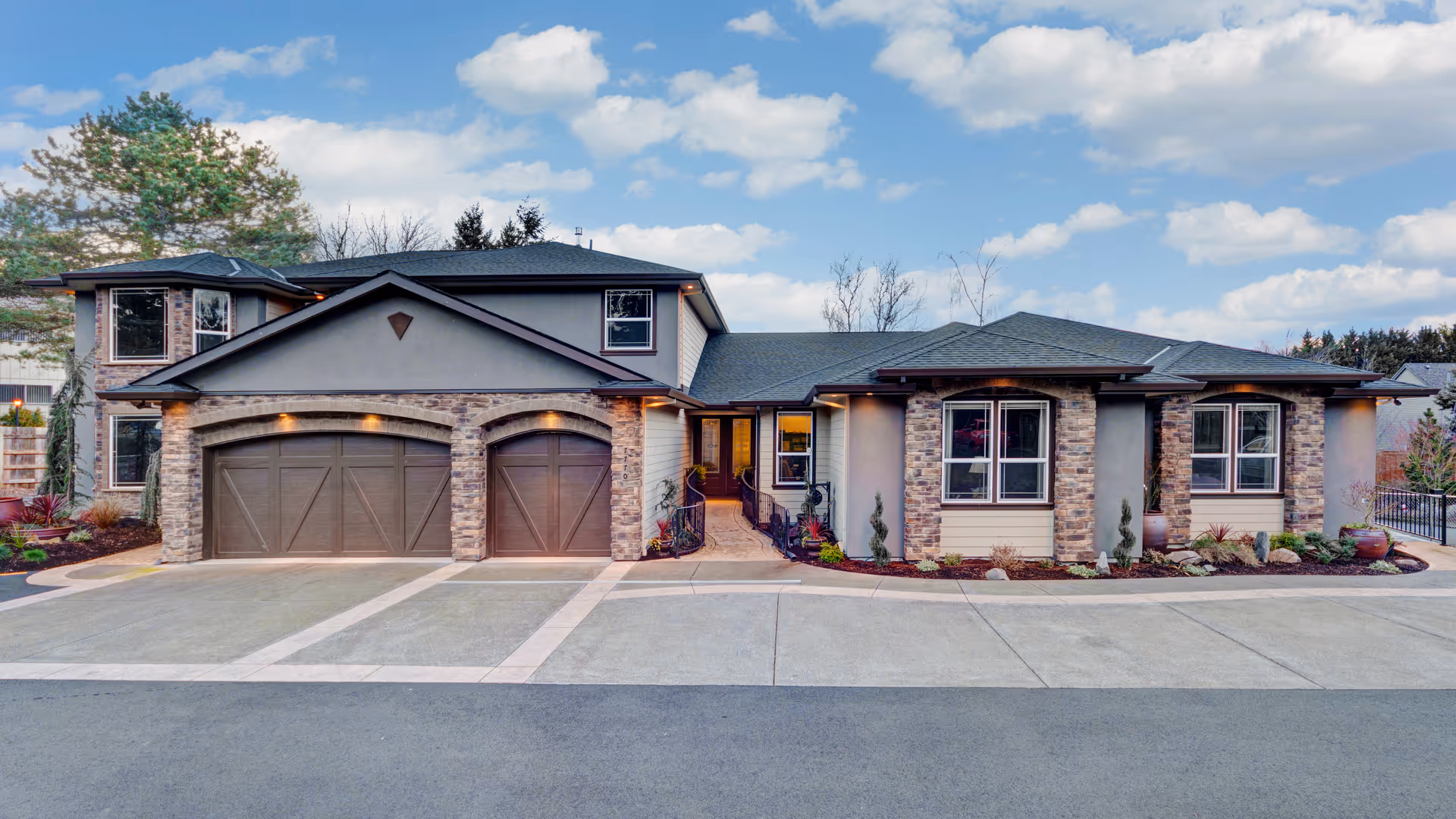 Exterior view of a modern senior care home with stone accents and garages.