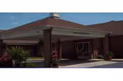 Front entrance of Blue Ridge Manor, brick senior living facility with covered drive and plants.