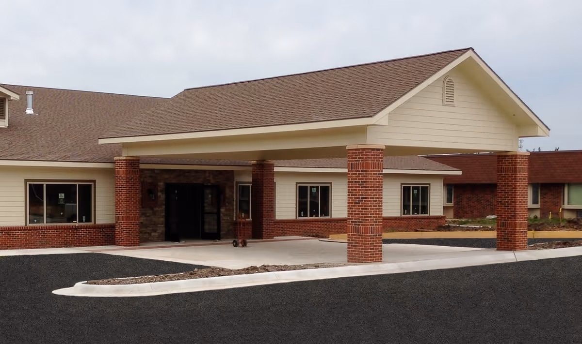 Front exterior view of Wellsville Manor, a senior living facility with a covered entrance.