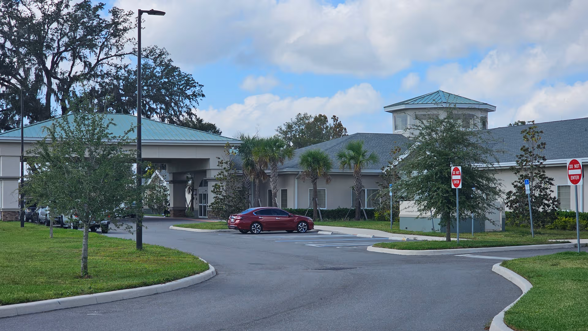 Exterior view of Guardian Care Nursing & Rehabilitation Center with driveway, entrance, and trees.