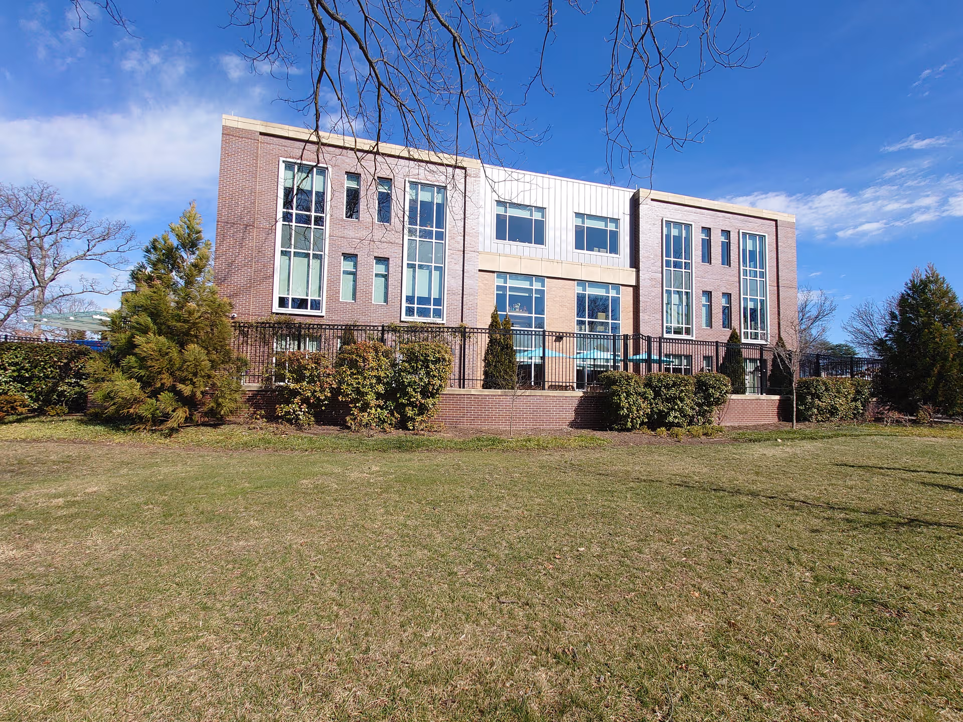 Brick memory care building with large windows and a manicured front lawn.