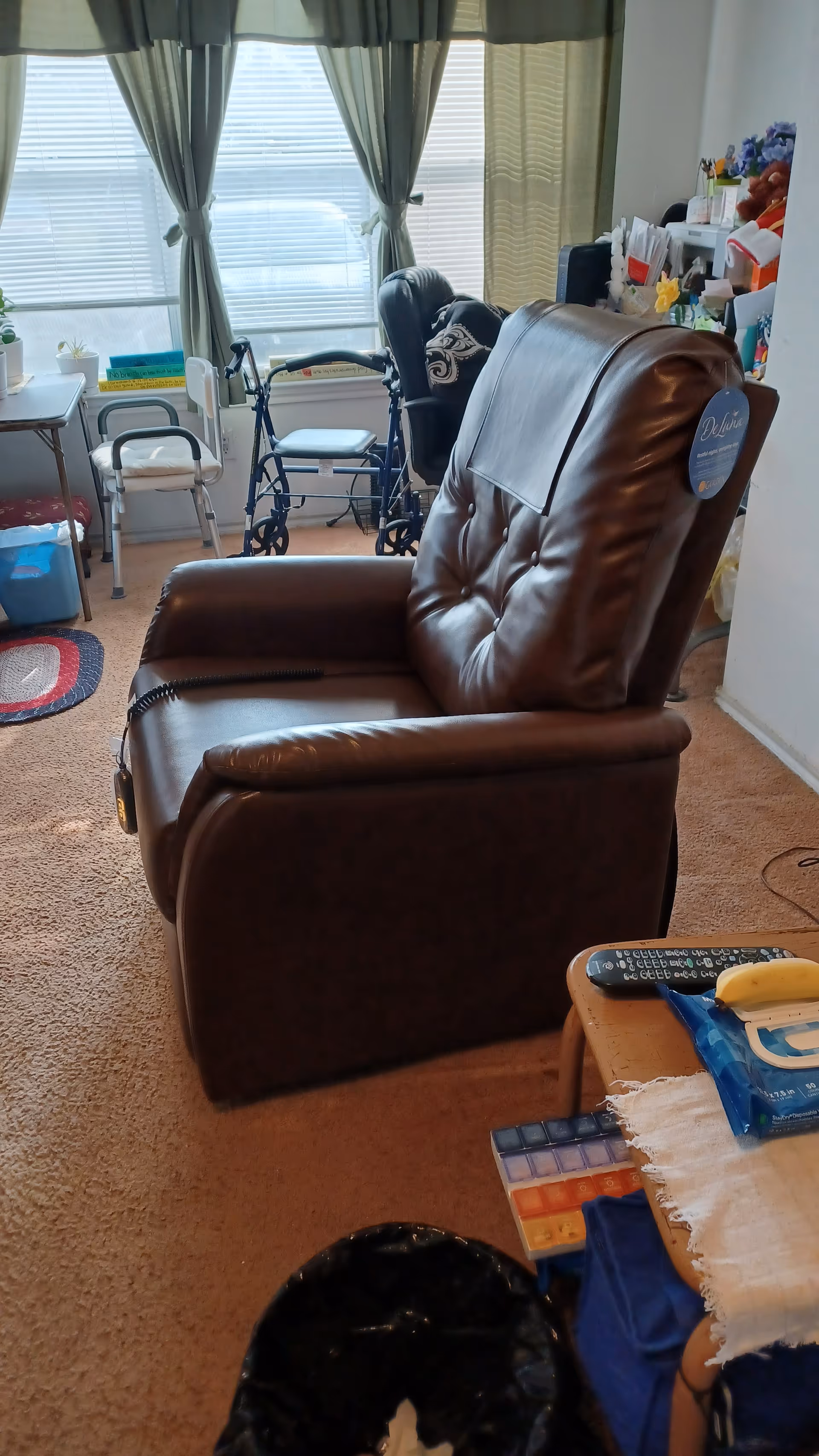 Cozy senior living room featuring a brown leather recliner and mobility devices.
