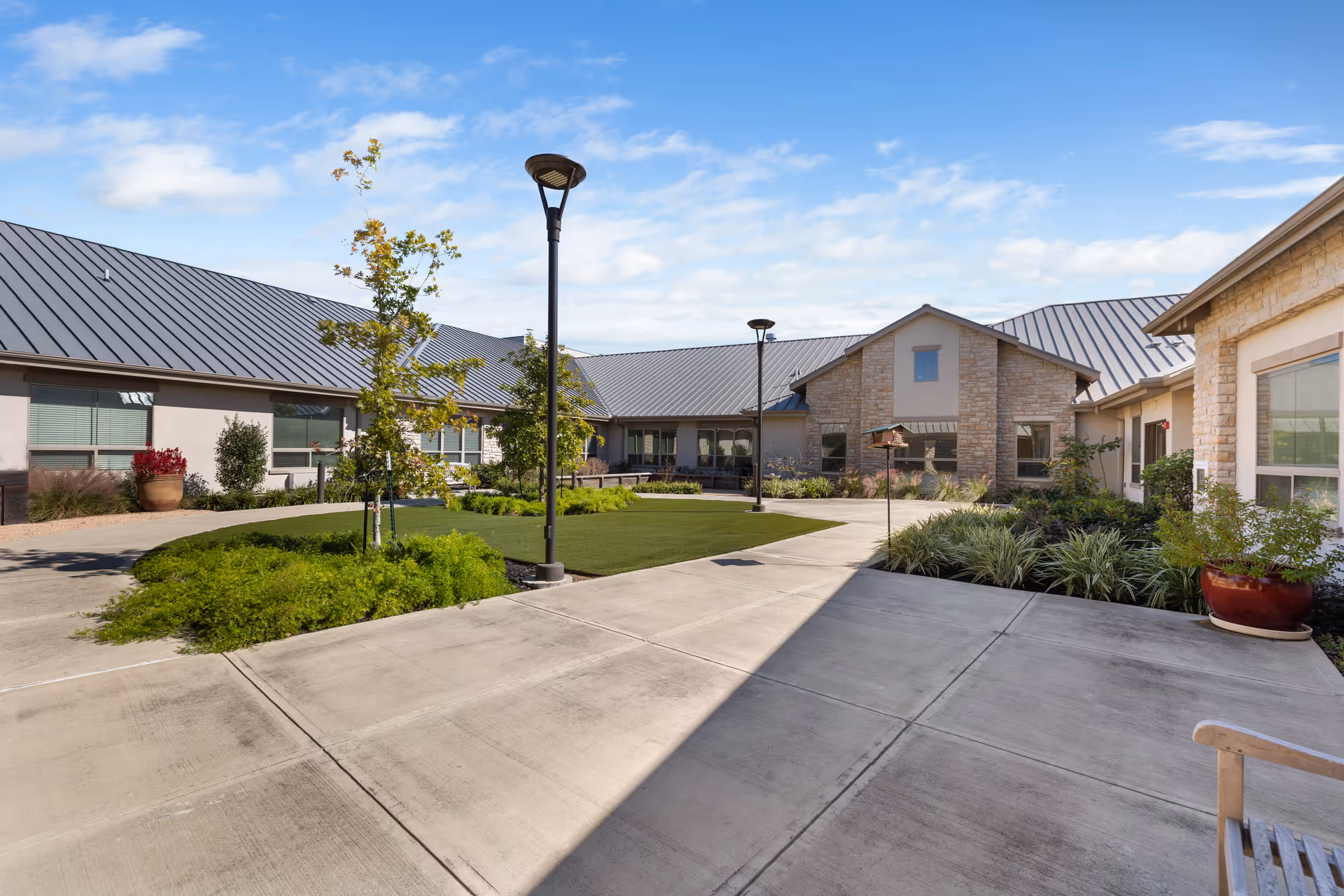 Exterior courtyard of Luxe Life Senior Living and Memory Care Katy with walkways and greenery.