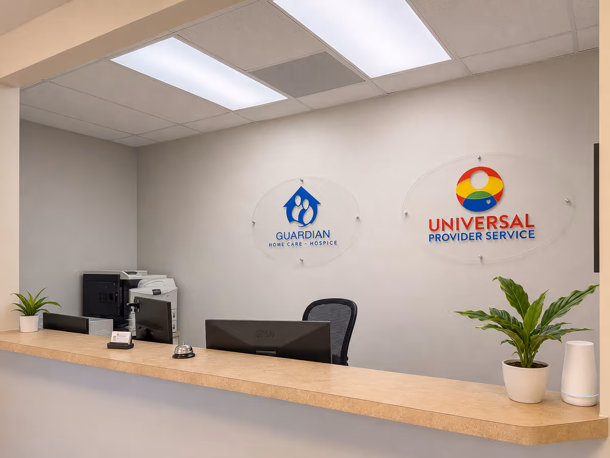 Reception desk with computer, printer, and Guardian Home Care signage in a bright interior.