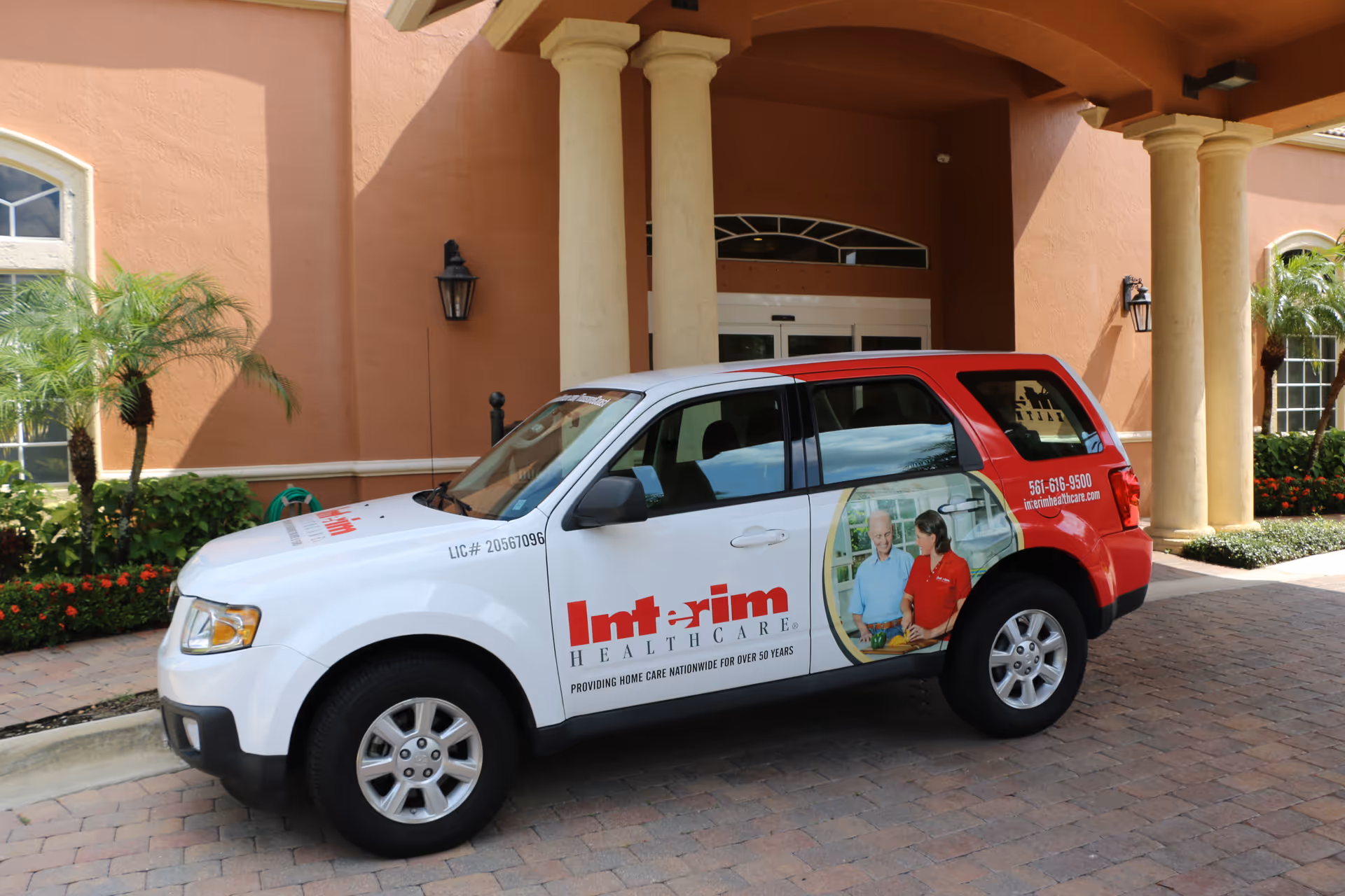 Interim HealthCare van parked outside a peach-colored building entrance in West Palm Beach